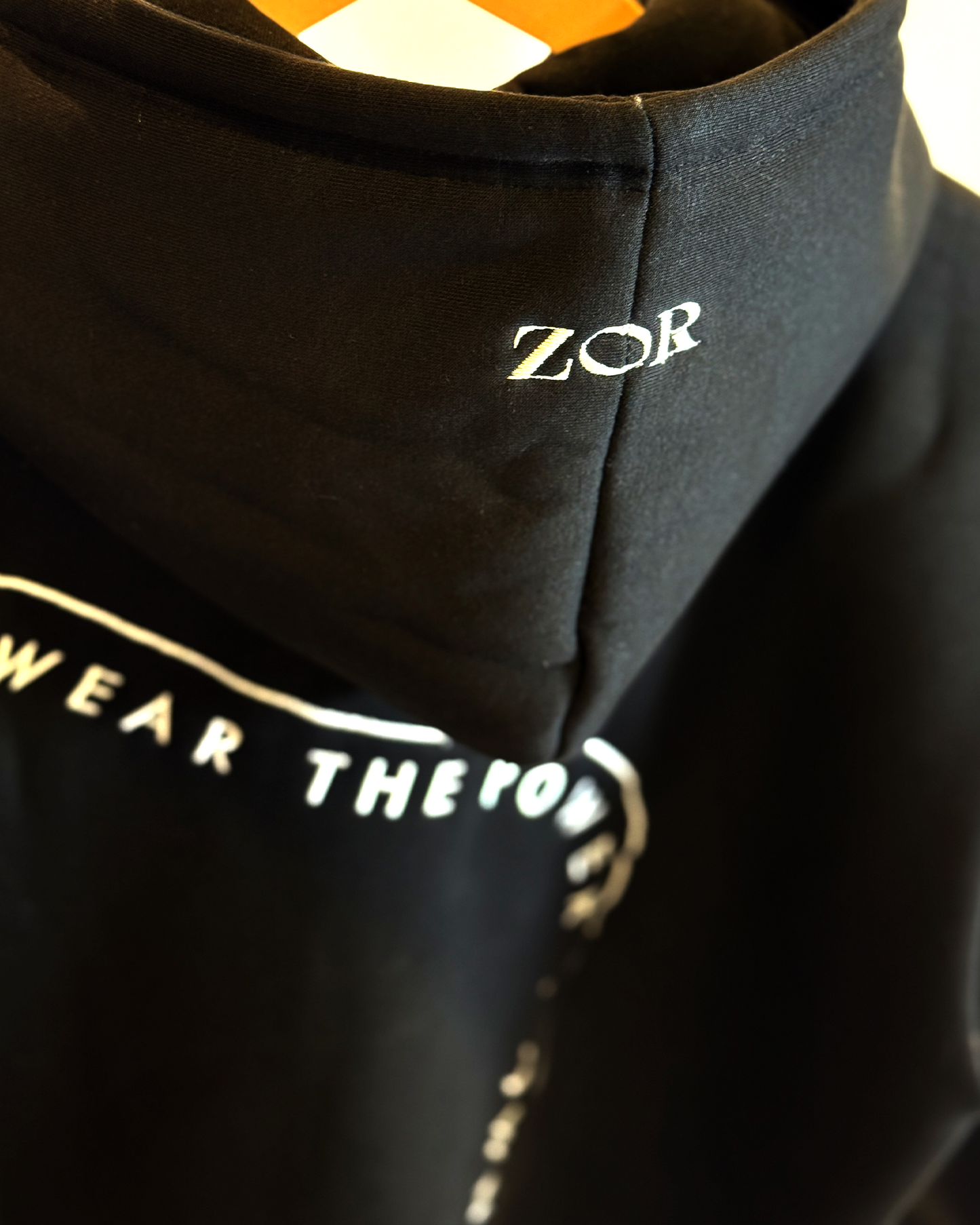 Zor Black Hoodie, Hoodies for Men, Hoodies for Women, Black hoodie with 'ZOR' branding and text on a blurred background