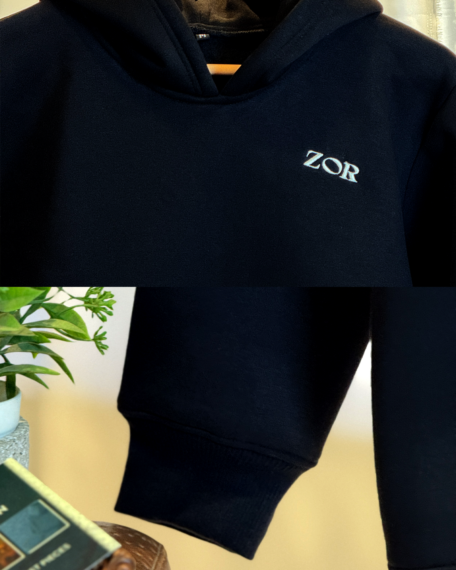 Zor Black Hoodie, Hoodies for Men, Hoodies for Women, Black hoodie with 'ZOR' logo on a blurred indoor background and hand sleeve closeup.